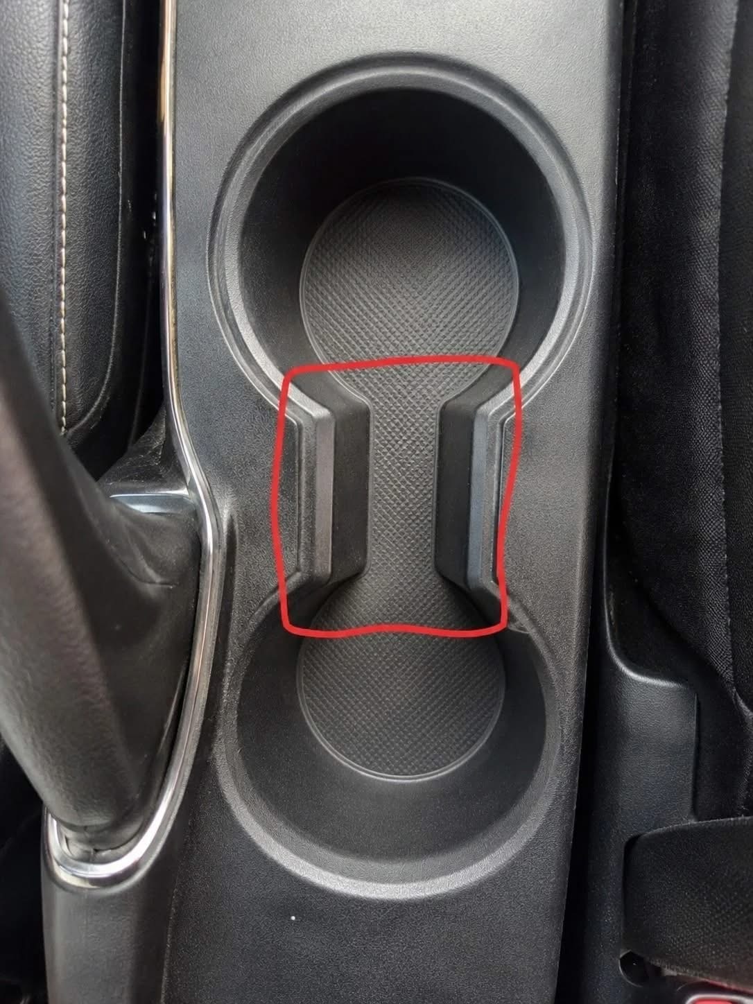 Waar dient die vreemde ruimte tussen de bekerhouders in een auto voor? …..